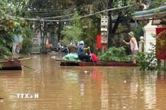 Người dân phải dùng thuyền để làm phương tiện di chuyển trong những ngày mưa lũ. (Ảnh: Việt Hoàng/TTXVN)