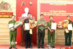 Thiếu tướng Nguyễn Thanh Liêm, Giám đốc Công an Quảng Trị trao thưởng của Bộ Công an cho các đơn vị có thành tích phá án nhanh. (Ảnh: Nguyên Linh/TTXVN)