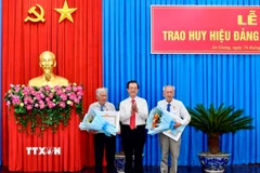 Ông Lê Hồng Quang, Bí thư Tỉnh ủy An Giang trao huy hiệu 65 năm tuổi Đảng cho 2 đảng viên. (Ảnh: Thanh Sang/TTXVN)