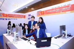 Phóng viên, biên tập viên của TTXVN tác nghiệp tại Trung tâm báo chí của Đại hội. (Ảnh: TTXVN phát)