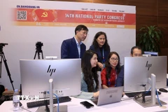 Phóng viên, biên tập viên của TTXVN tác nghiệp tại Trung tâm báo chí của Đại hội. (Ảnh: TTXVN phát)