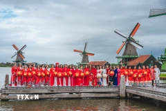 Tự hào những tà áo dài Việt Nam uyển chuyển giữa khung cảnh làng Cối xây gió - biểu tượng của đất nước Hà Lan. (Ảnh: TTXVN)