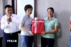 Tổng Giám đốc TTXVN Vũ Việt Trang tặng quà cho gia đình được TTXVN hỗ trợ xây dựng nhà mới. (Ảnh: Quang Cường/TTXVN)