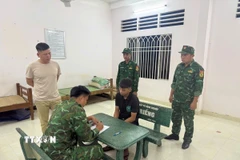 Lực lượng chức năng Đồn Biên phòng cửa khẩu Mỹ Quý Tây lấy lời khai của đối tượng Lê Anh Tuấn. (Ảnh: TTXVN phát)