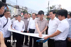 Bí thư Thành ủy Cần Thơ Lê Quang Tùng xem sơ đồ dự án mở rộng 7km Quốc lộ 91. (Ảnh: Thanh Liêm/TTXVN)