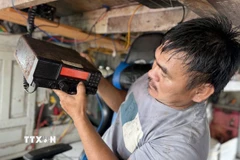 Ngư dân kiểm tra thiết bị giám sát hành trình trên biển trước khi ra khơi đánh bắt thủy sản. (Ảnh: Tường Quân/TTXVN)