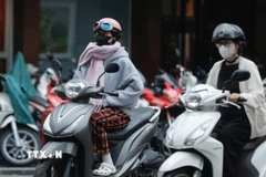 Người dân phải mặc áo ấm do nhiệt độ xuống thấp. (Ảnh minh họa: Minh Quyết/TTXVN)