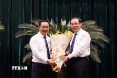 Ông Nguyễn Văn Nên (phải), Ủy viên Bộ Chính trị, Bí thư Thành ủy Thành phố Hồ Chí Minh chúc mừng Chủ tịch Ủy ban Nhân dân Thành phố Hồ Chí Minh Nguyễn Văn Được. (Ảnh: Xuân Khu/TTXVN)