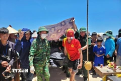Thi thể nạn nhân M.V.L. đã được đưa vào bờ làm thủ tục để bàn giao cho gia đình mai táng theo phong tục của địa phương. (Ảnh: TTXVN phát)