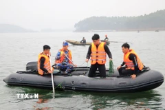 Lực lượng chức năng tìm kiếm các nạn nhân vụ chìm tàu khách tại hồ Thác Bà, Lào Cai ngày 22/2. (Ảnh: Đinh Thùy/TTXVN)