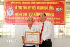 Bí thư Tỉnh ủy Cà Mau Nguyễn Hồ Hải trao Huy hiệu 80 năm tuổi Đảng cho đảng viên Vũ Khắc Trung (sinh năm 1928) tại xã Tân Lộc, tỉnh Cà Mau. (Ảnh: Huỳnh Anh/TTXVN)