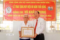 Bí thư Tỉnh ủy Cà Mau Nguyễn Hồ Hải trao Huy hiệu 80 năm tuổi Đảng cho đảng viên Vũ Khắc Trung (sinh năm 1928) tại xã Tân Lộc, tỉnh Cà Mau. (Ảnh: Huỳnh Anh/TTXVN)