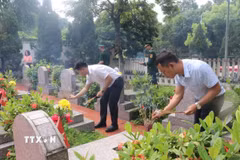 Thắp hương tại các phần mộ liệt sỹ. (Ảnh: Hương Thu/TTXVN)