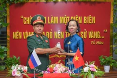 Thiếu tướng Lưu Trọng Lư, Chủ tịch Hội Cựu chiến binh tỉnh Điện Biên trao Hũ đựng đất thiêng cho bà Vũ Thị Tuyết Nga, Giám đốc Bảo tàng Chiến thắng Điện Biên Phủ. (Ảnh: Xuân Tư/TTXVN)
