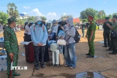 Lực lượng chức năng Việt Nam-Campuchia làm thủ tục bàn giao, tiếp nhận 353 công dân Việt Nam tại Cửa khẩu quốc tế Xa Mát, xã Tân Lập, tỉnh Tây Ninh. (Ảnh: TTXVN phát)