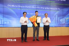 Lãnh đạo Ủy ban Nhân dân thành phố Cần Thơ trao Giấy chứng nhận đăng ký đầu tư và hoa cho Công ty Cổ phần đầu tư Khu công nghiệp Mekong Cần Thơ. (Ảnh: Ngọc Thiện/TTXVN)