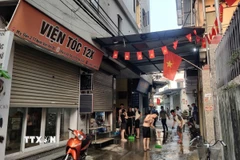 Người dân dọn dẹp hiện trường vụ nổ. (Ảnh: TTXVN phát)