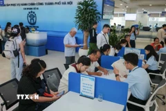 Công dân đến làm thủ tục hành chính được hướng dẫn, tư vấn miễn phí, giải đáp những thắc mắc về các thủ tục, đặc biệt trong thủ tục đất đai. (Ảnh: Hoàng Hiếu/TTXVN)