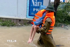 Chiến sỹ Phòng Cảnh sát phòng cháy, chữa cháy và cứu nạn, cứu hộ (Công an tỉnh Thanh Hóa) nỗ lực tiếp cận hộ dân ở thôn Bái, xã Trường Lâm (Thanh Hóa). (Ảnh: TTXVN phát)