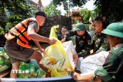 Cán bộ chiến sỹ Sư đoàn 3 (Quân khu 1) hỗ trợ vận chuyển hàng tiếp tế cho người dân tại thôn Phú Cốc, xã Hợp Thịnh. (Ảnh: Danh Lam/TTXVN)