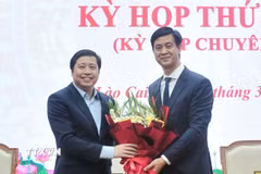 Đồng chí Dương Quốc Huy, Ủy viên Ban Chấp hành Trung ương Đảng, Bí thư Tỉnh ủy Lào Cai tặng hoa chúc mừng đồng chí Phan Trung Bá. (Ảnh: Tuấn Khôi/TTXVN)