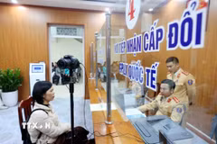 Cán bộ, chiến sỹ Đội Sát hạch, cấp giấy phép lái xe cơ giới đường bộ (Phòng Cảnh sát Giao thông, Công an thành phố Hà Nội) làm thủ tục cấp, đổi giấy phép lái xe cho công dân. (Ảnh: Phạm Kiên/TTXVN)