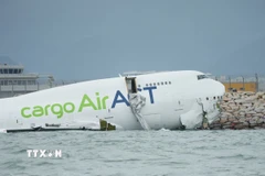 Hiện trường vụ máy bay chở hàng trượt khỏi đường băng và lao một phần xuống biển ở sân bay quốc tế Hong Kong, Trung Quốc ngày 20/10/2025. (Ảnh: THX/TTXVN)
