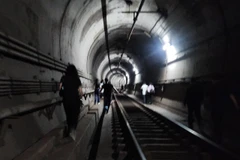 Hành khách được sơ tán khẩn cấp qua đường hầm. (Nguồn: Yonhap)