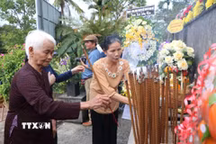 Thân nhân các nạn nhân vụ thảm sát dâng hương. (Ảnh: Đinh Hương/TTXVN)