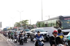 Phương tiện xếp hàng dài, di chuyển chậm qua các nút giao trên Quốc lộ 1, đoạn từ nút giao với đường Nguyễn Văn Linh đến đường Nguyễn Hữu Trí. (Ảnh: Tiến Lực/TTXVN)