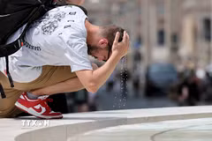 Một khách du lịch làm mát tại đài phun nước ở Rome, Italy. (Ảnh: THX/TTXVN phát)