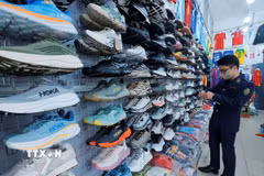 Lực lượng chức năng kiểm tra sản phẩm giầy tại cửa hàng. (Ảnh: Trần Việt/TTXVN)