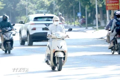 Trong ngày nắng nóng, trang phục kín mít là một lựa chọn tối ưu. (Ảnh: Hoàng Hùng/TTXVN)