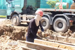 Công nhân căng mình làm việc trong điều kiện thời tiết nắng nóng gay gắt để đảm bảo tiến độ dự án. (Ảnh: Nguyễn Thắng/TTXVN)