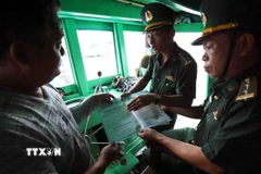 Lực lượng Bộ đội Biên phòng tuyên truyền, vận động ngư dân khai thác thuỷ sản đúng quy định của pháp luật ở cảng cá Quy Nhơn. (Ảnh: Vũ Sinh/TTXVN)