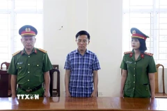 Ông Nguyễn Văn Hưng (giữa), nguyên Chủ tịch UBND xã Lộc Yên, bị khởi tố về hành vi để hơn 264 tấn xi măng phục vụ xây dựng nông thôn mới bị hư hỏng. (Ảnh: TTXVN phát)