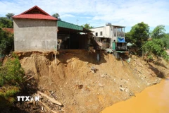 Sau khi lữ dữ càn quét qua, nhiều ngôi nhà của người dân trên địa xã Mường Xén (tỉnh Nghệ An) nằm chênh vênh bên bờ vực sông Nậm Mộ, nguy cơ sạt lở rất cao. (Ảnh: Xuân Tiến/TTXVN)