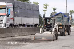 Thu gom lớp áo đường bị hư hỏng. (Ảnh: Mai Trang/TTXVN)