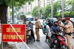 Cảnh sát Giao thông kiểm tra nồng độ cồn với người tham gia giao thông. (Ảnh: Phạm Kiên/TTXVN)