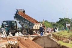 Đơn vị quản lý đường bộ tỉnh Khánh Hòa khắc phục sạt lở do mưa lũ tại tuyến đường 703. (Ảnh: Công Thử/TTXVN)