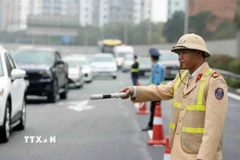 Cảnh sát giao thông điều tiết, phân luồng phương tiện. (Ảnh: Phạm Kiên/TTXVN)
