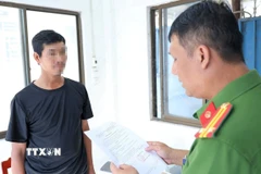 Cơ quan Cảnh sát điều tra Công an tỉnh An Giang tống đạt các quyết định khởi tố và lệnh tạm giam đối với bị can Nguyễn Thành Trung. (Ảnh: Công Mạo/TTXVN)