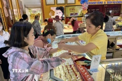 Giao dịch vàng khá sôi động trong thời điểm giá vàng tăng sốc. (Ảnh: Hứa Chung/TTXVN)