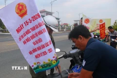 Gắn thông tin tuyên truyền bằng xe gắn máy trên địa bàn xã Vĩnh Viễn, thành phố Cần Thơ. (Ảnh: Duy Khương/TTXVN)