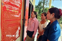 Đồng bào Bru - Vân Kiều (xã Trường Sơn, Quảng Trị) đọc các quy định về công tác bầu cử. (Ảnh: TTXVN phát)