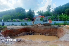 Đơn vị thi công tiến hành thả đá hộc xuống hố. (Ảnh TTXVN phát)