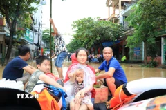 Người dân được lực lượng chức năng tỉnh Lào Cai hỗ trợ di chuyển đến nơi an toàn. (Ảnh: Tuấn Anh/TTXVN)