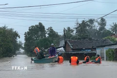 Lực lượng chức năng Phường Sông Cầu tổ chức cứu nạn người dân ở khu vực ngập sâu. (Ảnh: TTXVN phát)