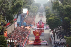 Lễ diễu binh bắt đầu với Đội hình xe mô hình Quốc huy nước Cộng hòa Xã hội Chủ nghĩa Việt Nam và xe rước chân dung Chủ tịch Hồ Chí Minh diễu qua Lễ đài. (Ảnh: TTXVN)