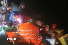 Các thuyền viên gặp nạn được tổ công tác Đồn Biên phòng Rạch Gốc đưa lên tàu an toàn. (Ảnh: TTXVN phát)